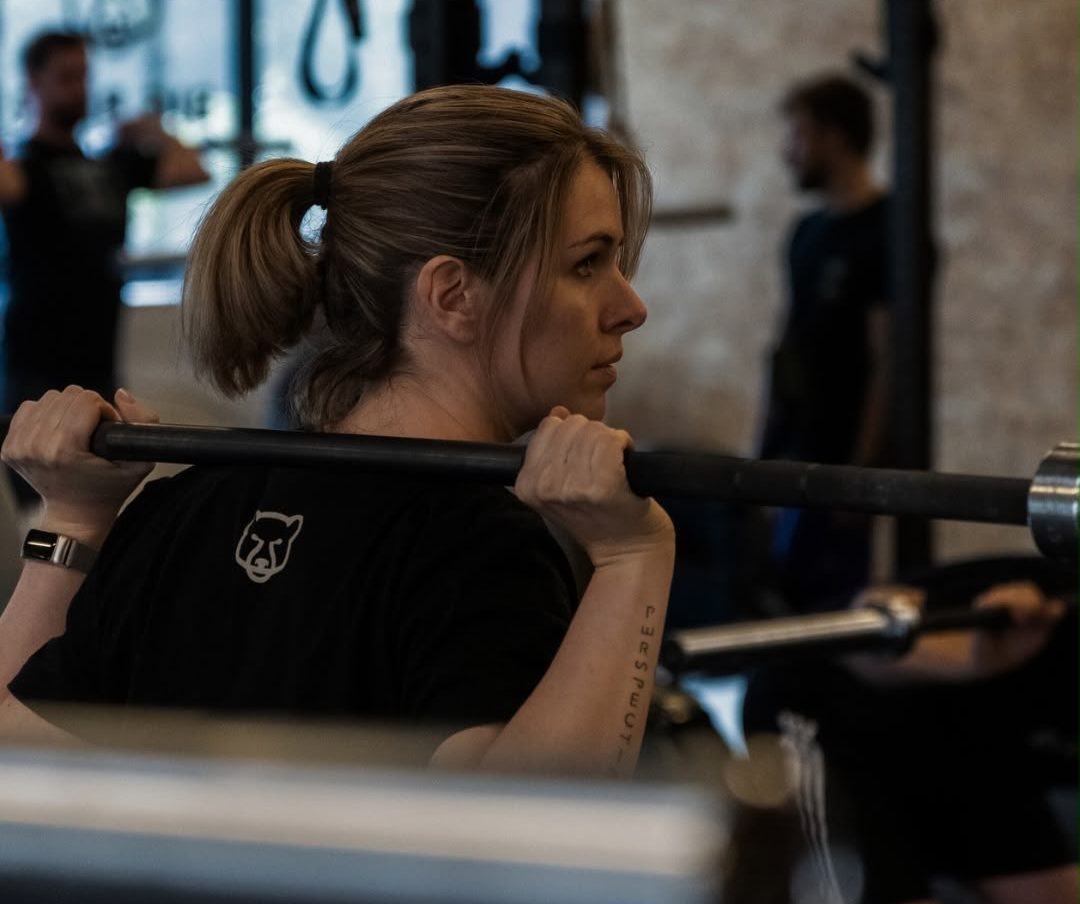 Athletin mit Langhantel auf den Schultern